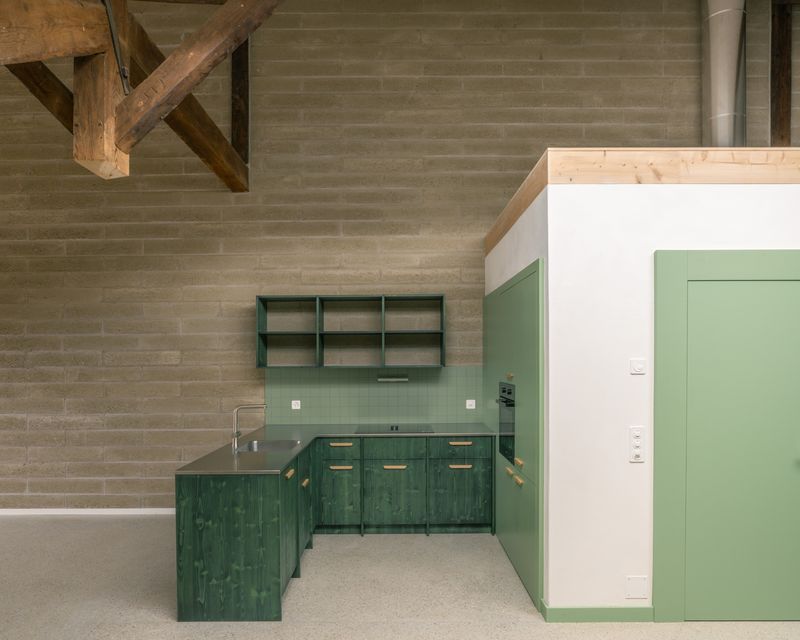 Transformation d'un moulin en logements – Cuisine de l'appartement des combles et mur porteur en briques de terre crue – Brian Scott Adkins