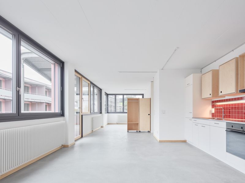 Lise & Lotte, Umbau und Umnutzung Sägestrasse 76/78, Köniz – Die Wohnungen orientieren sich horizontal entlang der Bandfenster, ausgestattet mit mobilen Tablarschränken und Garderoben aus Holz – Edward Greiner