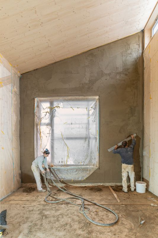 Werkhof 29 – Aufbringen des Lehmputzes auf die mit Strohballen gedämmten Aussenwände – Martin Zeller