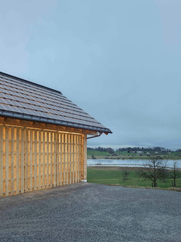 Ökonomiegebäude Lützelsee – Aussenansicht der Remise in der Dämmerung mit Blick auf den Lützelsee – Foto: Andreas Graber