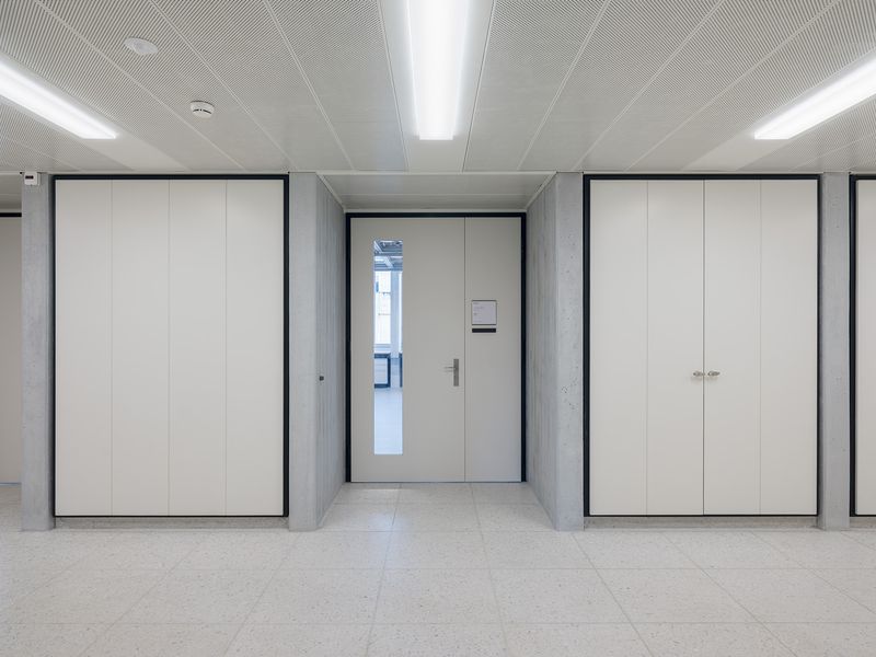 Umbauten HPT – Neue brandschutzkonforme Einbauten in den Korridoren folgen dem Rhythmus der Tragstruktur und greifen die ursprüngliche Materialität wieder auf. – Beat Bühler