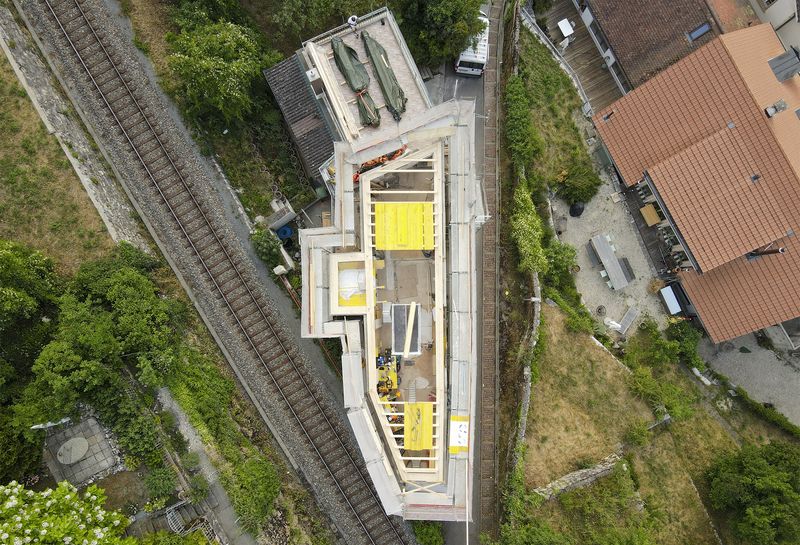 Felsenburg – foto aerea dell'edificio durante la fase di montaggio della struttura in legno, vicinanza estrema con la linea ferroviaria – Cyril Käppeli