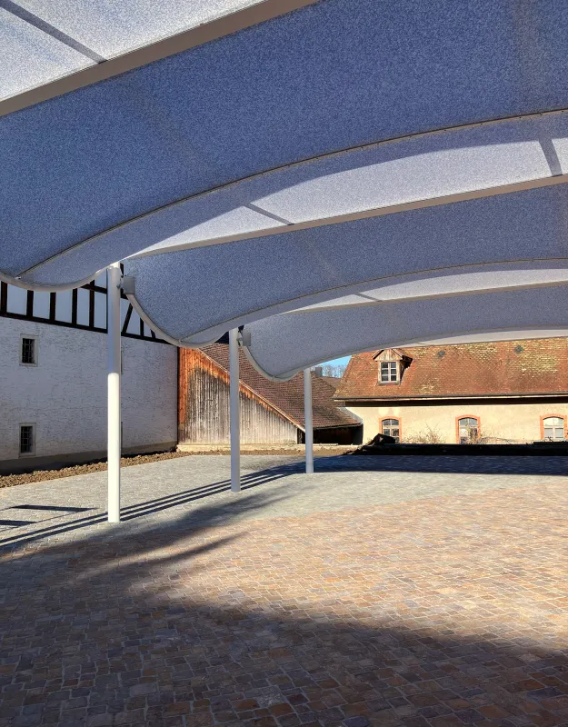 Arealgestaltung Mariastein – Ein Klosterplatz als Gastgeber – Das Pilgerforum ergänzt die Nachbarbauten in ihrer Funktion und bietet das ganze Jahr über Schatten und Regenschutz, Geborgenheit und Offenheit – Atelier Ehrenklau Hemmerling GmbH