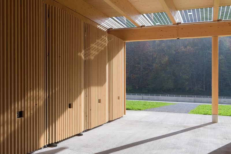 Wassersport- und Kulturzentrum, Ittigen/Worblaufen – Gedeckter Zugang mit Holzstütze, Vordach aus Glas mit intergierter transluzider PV-Anlage – Christine Blaser, Bildaufbau, Bern