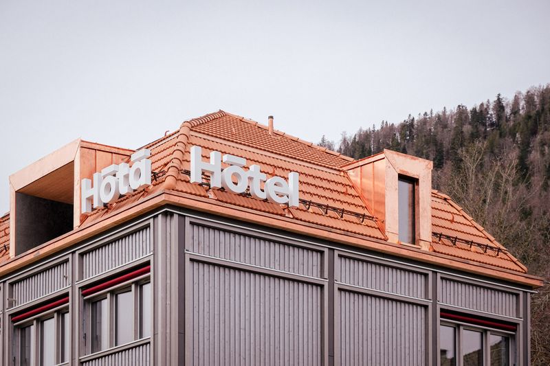 Hôtâ Hôtel St-Imier – Enseigne de l'hôtel sur l'angle Sud-Est en direction de la gare – ©GINAA architectes Sàrl