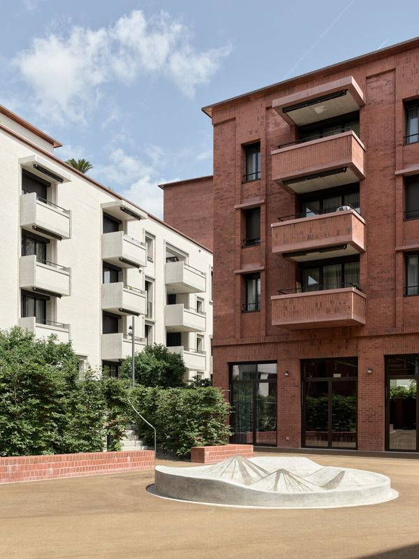 Chäsimatt – Auf dem Foyer befindet sich der Brunnen, der im Sommer für Abkühlung sorgt. Der Farbwechsel an den Fassaden und die dichte Bepflanzung deuten auf einen Wechsel im Öffnungsgrad hin. – © 2018 by Ariel Huber / EDIT images