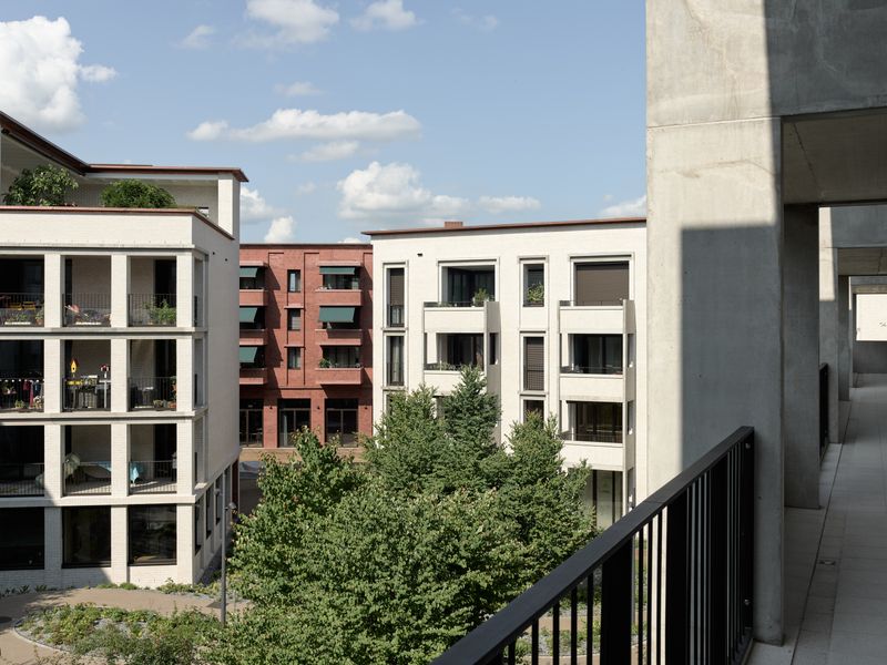 Chäsimatt – Blick vom Laubengang aus dem Innenhof B in Richtung Foyer. Die weissen Innenhoffassaden aus Klinker werden mit grauen Betonelementen aufgelockert. Jedes Gebäude erhält eine individuelle Ausgestaltung. – © 2018 by Ariel Huber / EDIT images